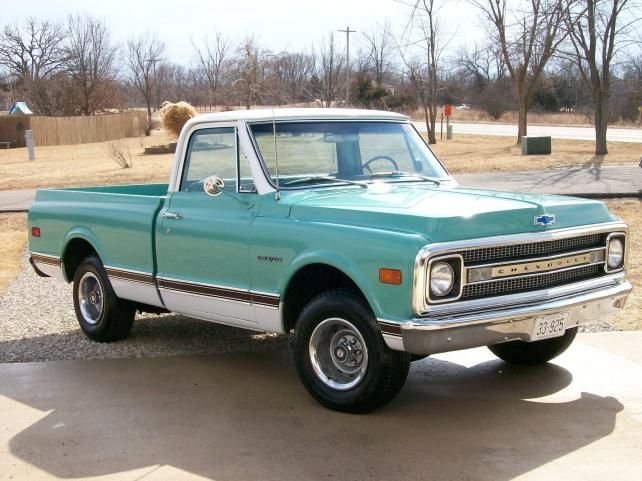 an old pickup truck parked in a driveway