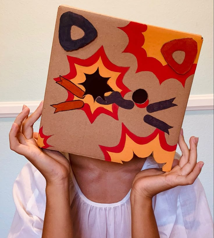 a woman is holding up a cardboard box with an image of a cat on it