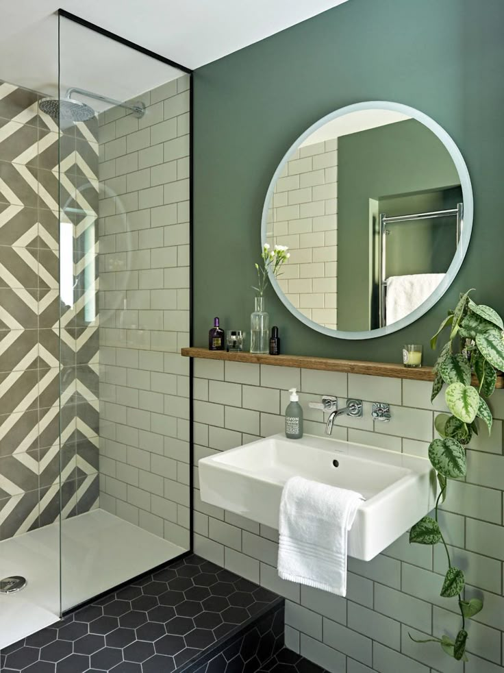 a white sink sitting under a bathroom mirror next to a walk in bathtub and shower