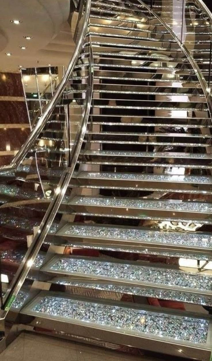 an escalator with glass steps leading up to the second floor