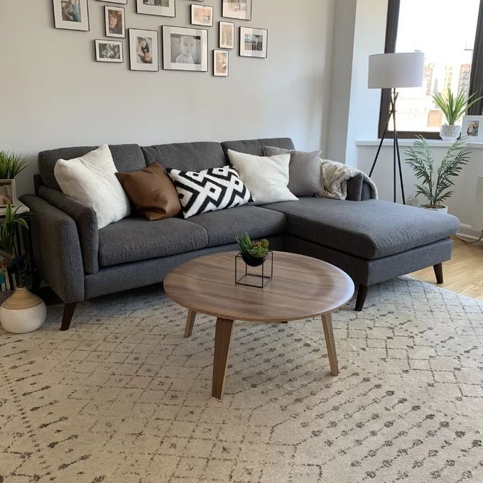 a living room filled with furniture and lots of pictures on the wall above it's coffee table