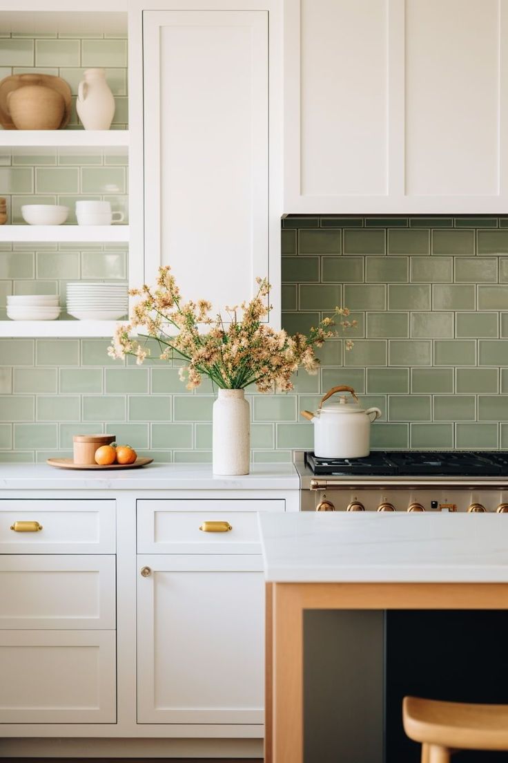 a kitchen with white cabinets and green tile backsplash, flowers in a vase on the stove