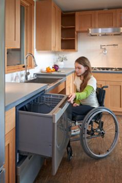 a woman in a wheel chair is looking into the kitchen