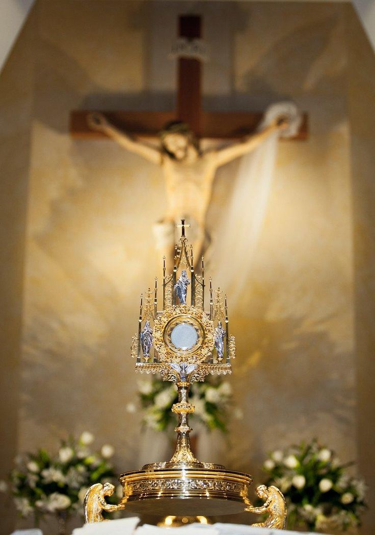 a crucifix with flowers in front of it and a cross behind it