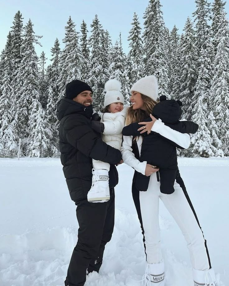 two adults and a child standing in the snow