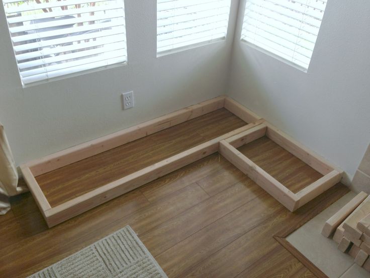 an empty room with wood flooring and windows