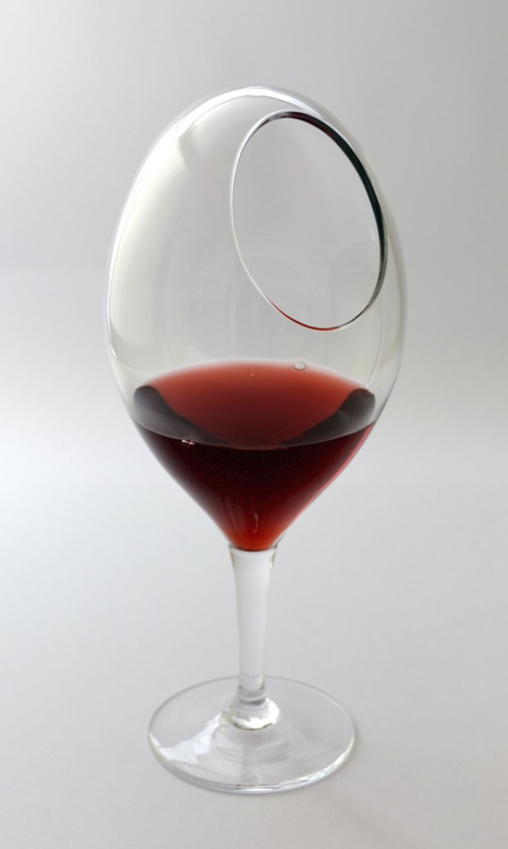 a glass filled with red wine sitting on top of a table