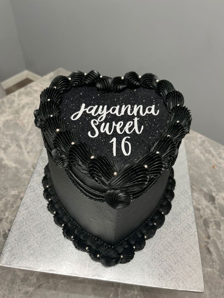 a black heart shaped cake with the words savannah sweet written on it's side