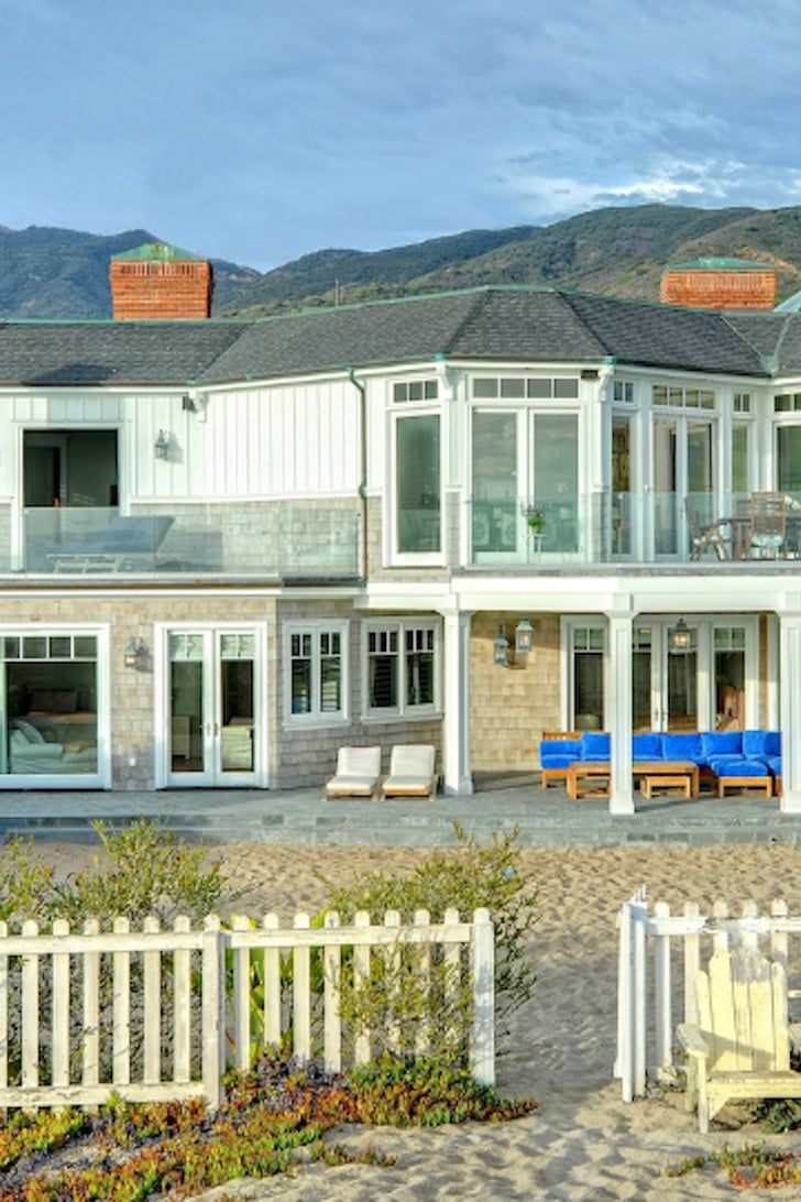 a large white house sitting on top of a sandy beach