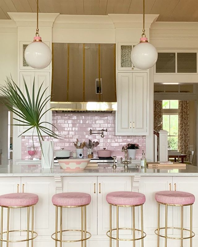 three pink stools in front of a kitchen island