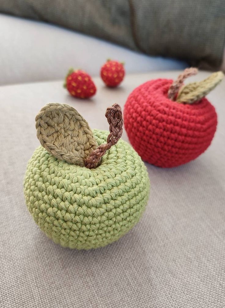 two crocheted apples sitting next to each other