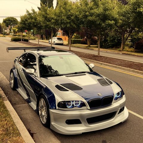 a white and blue car is parked on the side of the road