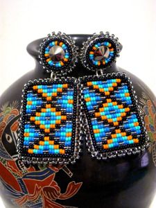 a black vase with blue and orange beaded designs on it