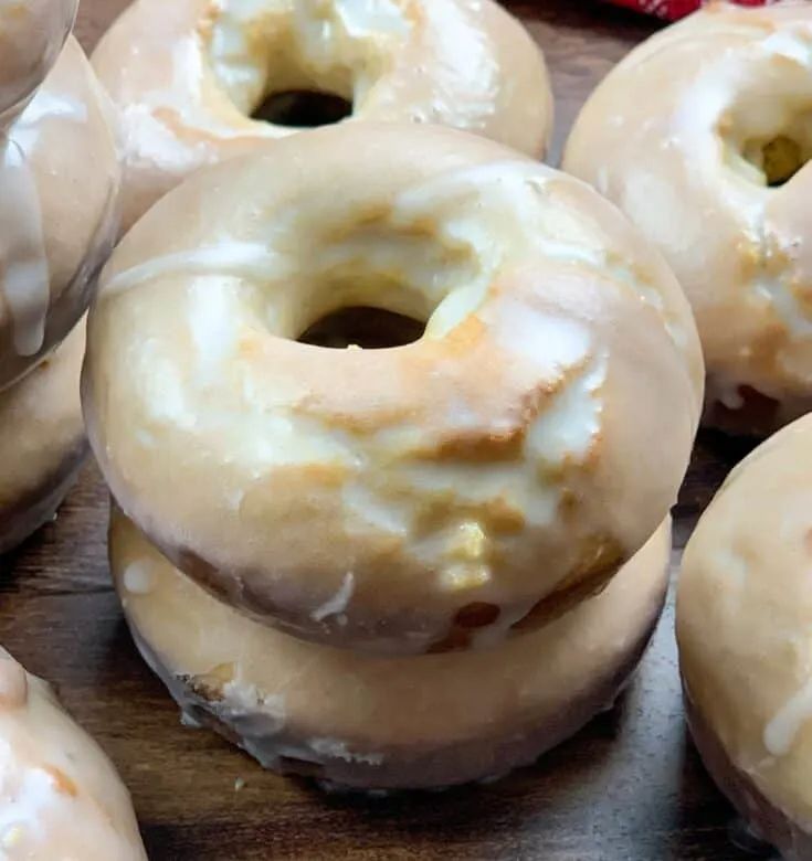 glazed donuts with icing on a wooden table