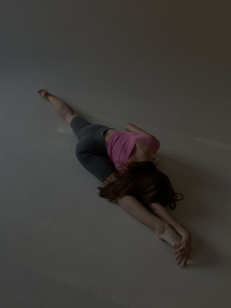 a woman is laying on the floor with her hands behind her head and arms outstretched