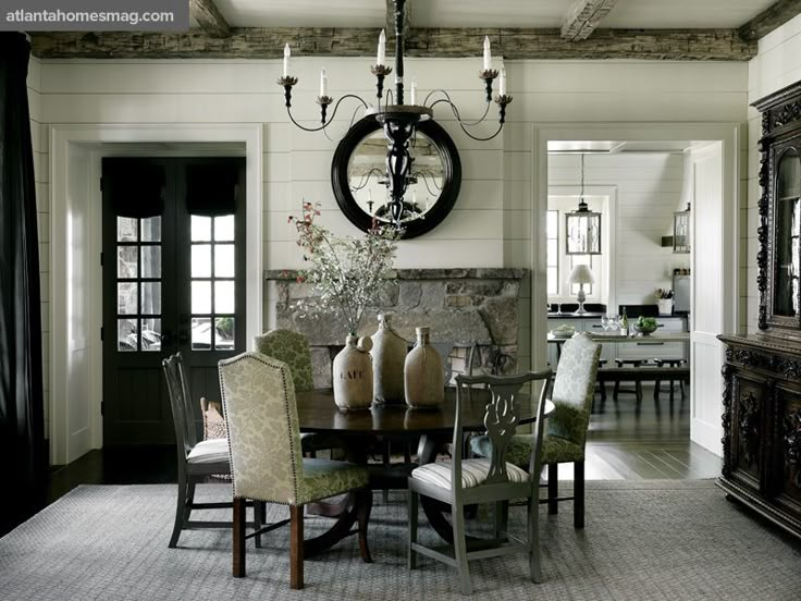 a dining room table with chairs and a chandelier hanging from it's ceiling