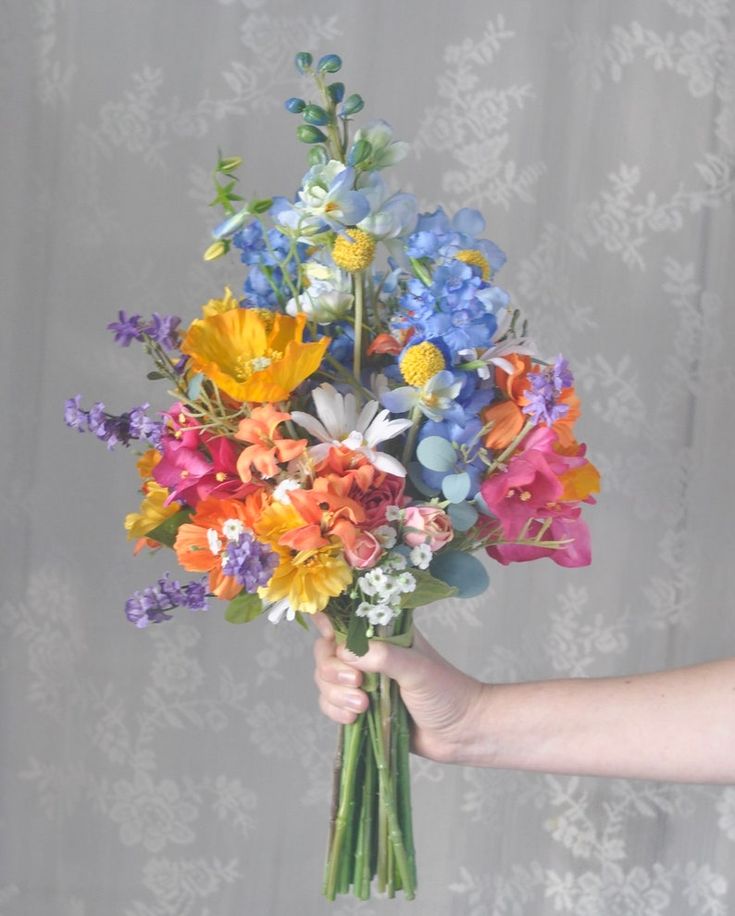 a person holding a bouquet of colorful flowers