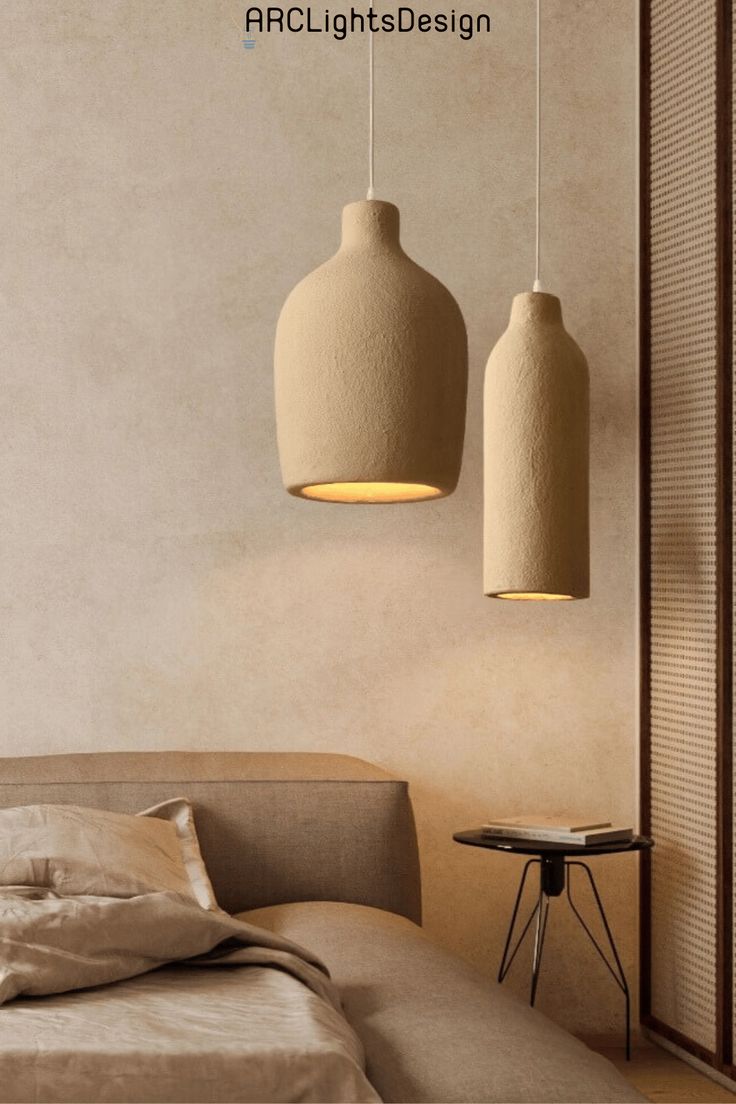 two lamps hanging from the ceiling above a bed