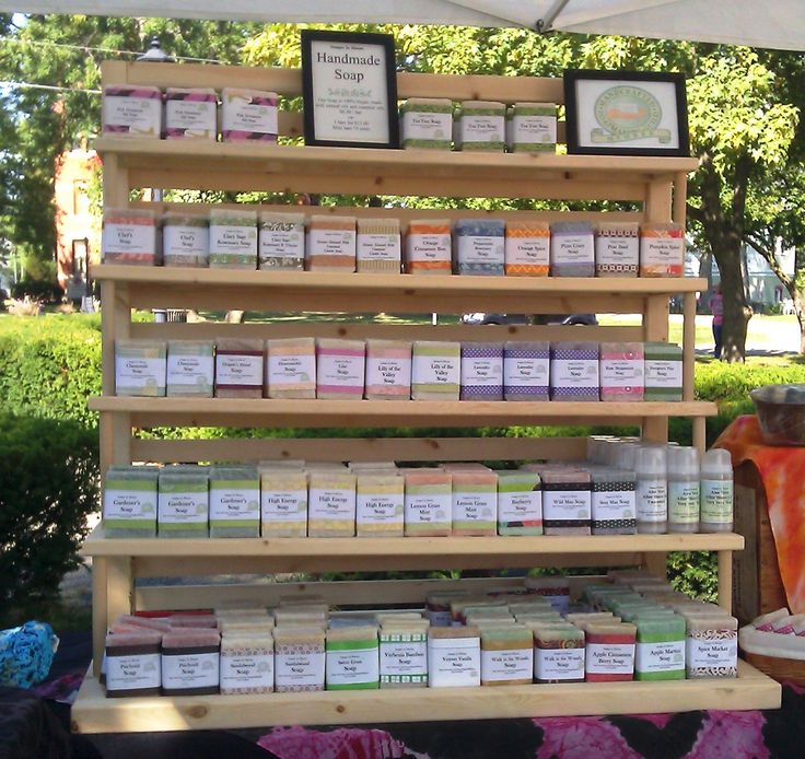 an outdoor display with soaps, candles and other items for sale under a tent