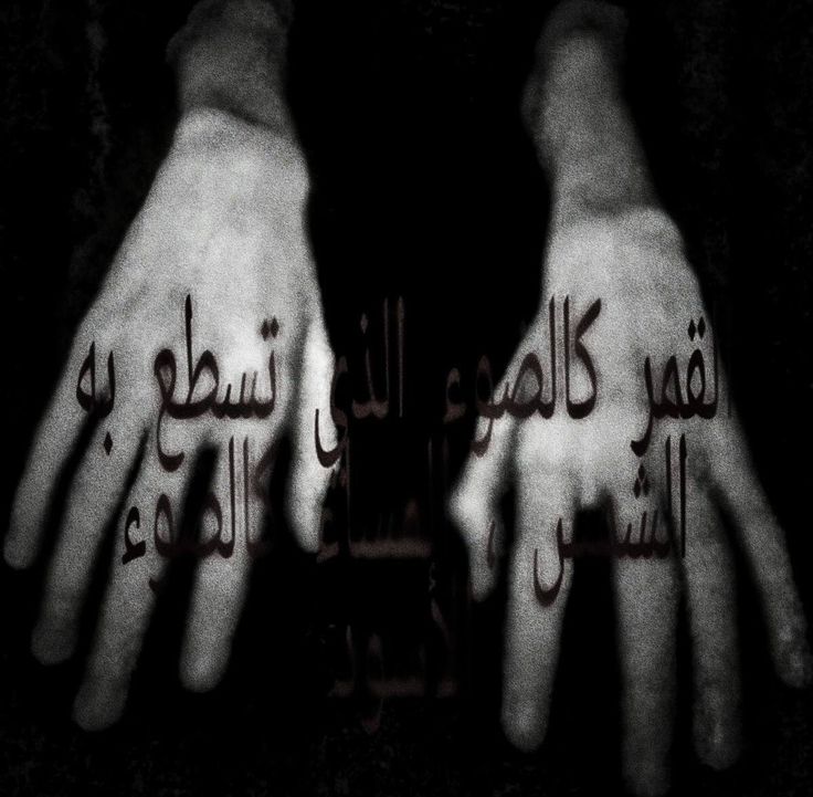 two hands with arabic writing written on their palms in black and white, against a dark background