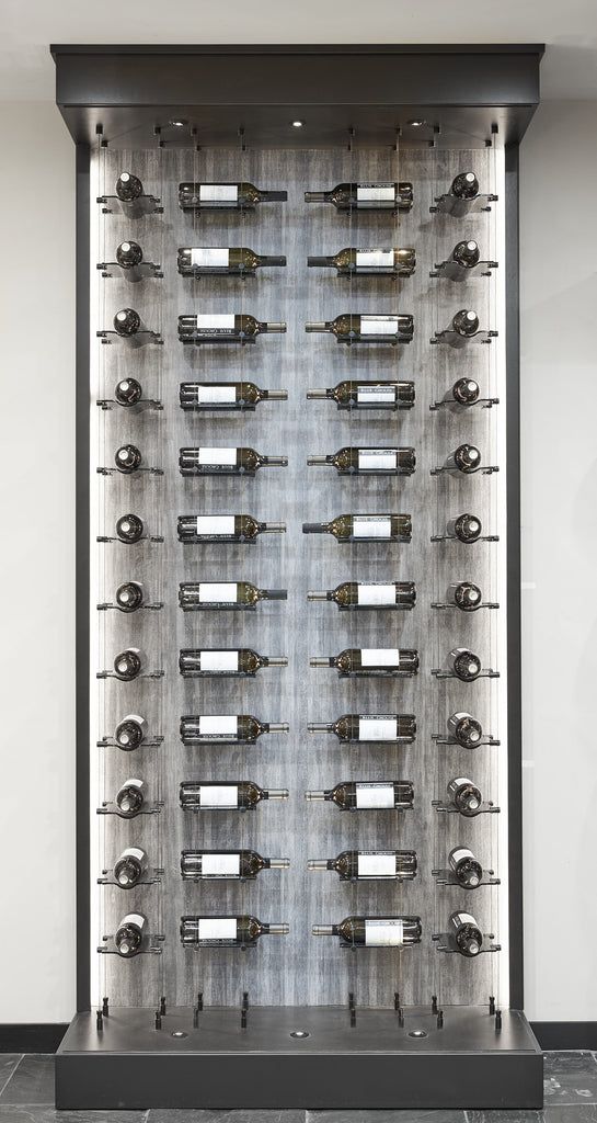 a wine rack with many bottles on it in front of a white wall and black tile floor