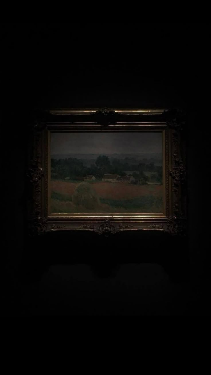 a painting hanging on the wall in a dark room