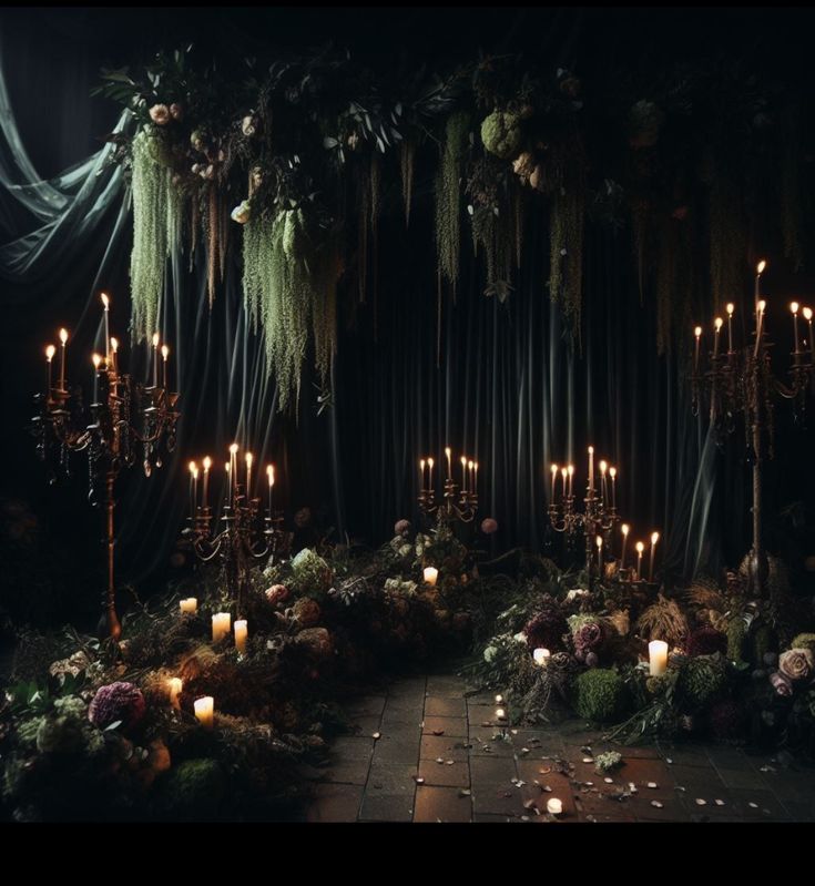 a dark room with candles and greenery on the walls, surrounded by mossy garlands