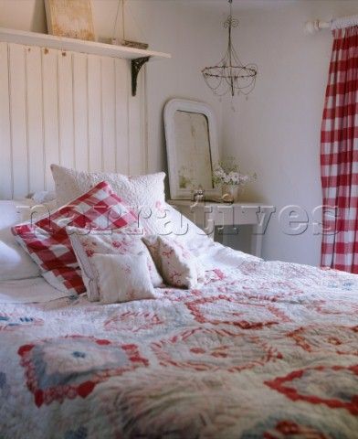 the bed is made with red and white quilts