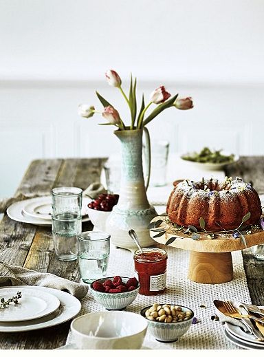 a table is set with plates, cups and cake