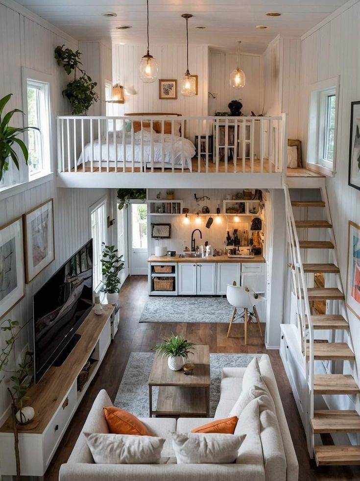 a living room filled with furniture and a fire place next to a staircase leading up to a loft