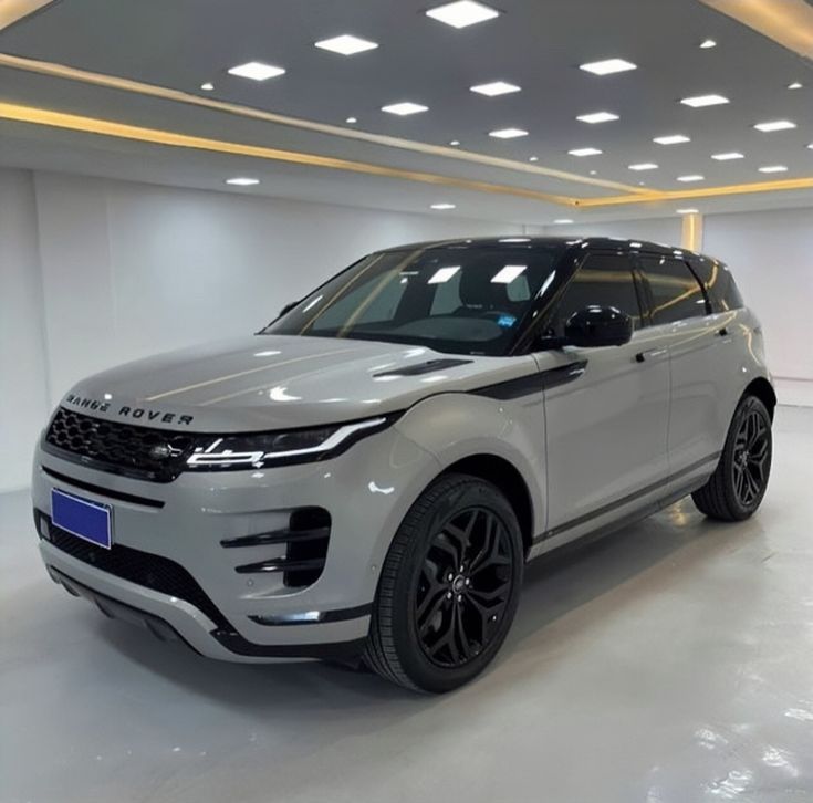 a white range rover parked in a large room