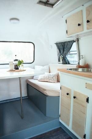 the inside of a camper with a table and sink