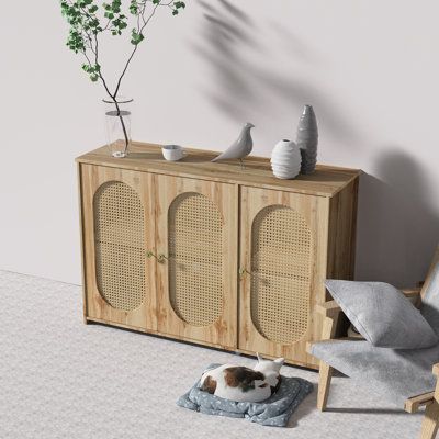 a dog laying on top of a bed in front of a wooden cabinet with doors