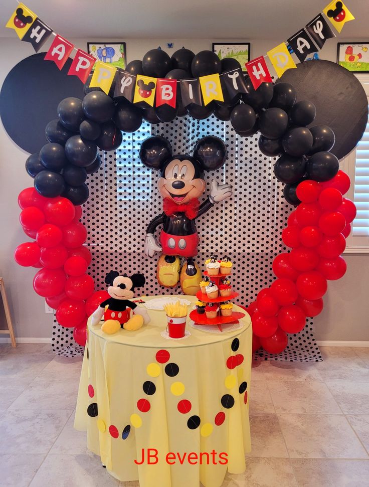 a mickey mouse birthday party with balloons and decorations