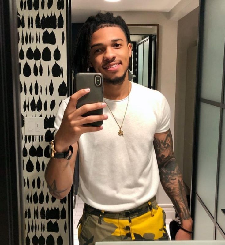 a man is taking a selfie in the mirror while wearing shorts and a white t - shirt