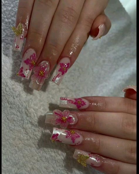 a woman with pink and gold flowers on her nails