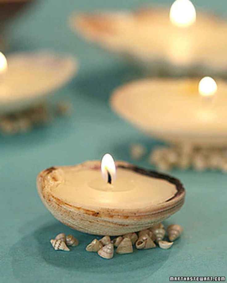 a lit candle sitting on top of a table next to some rocks and pebbles in front of it