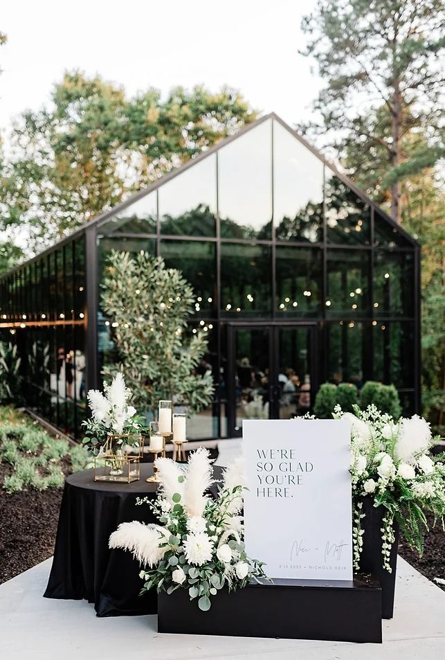 a sign that is sitting on top of a table with flowers and candles in front of it