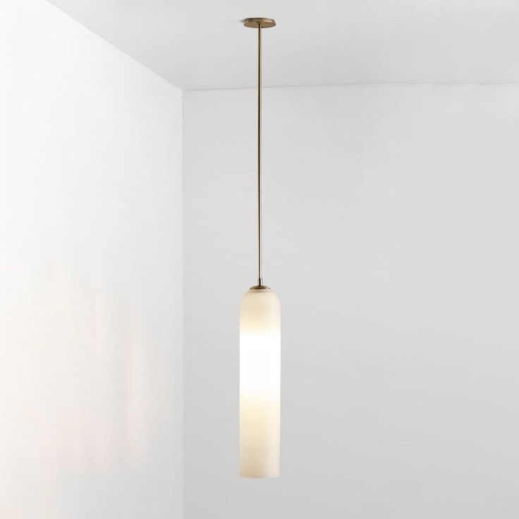 a light fixture hanging from the ceiling in a room with white walls and flooring