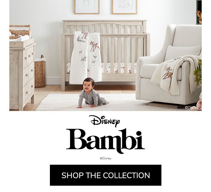 a baby laying on the floor in front of a white crib with disney's logo