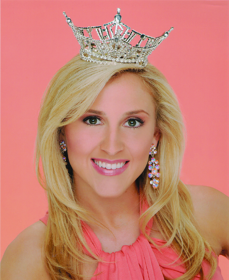 a woman wearing a tiara and smiling at the camera