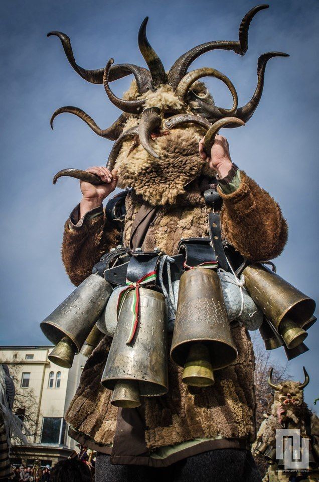 a man dressed as an animal with horns and bells on his head, wearing armor