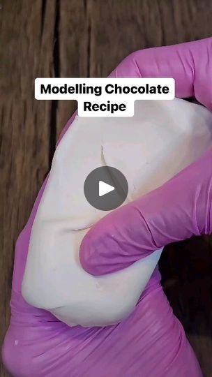 a person in purple gloves holding a white bag with the word modeling chocolate recipe on it