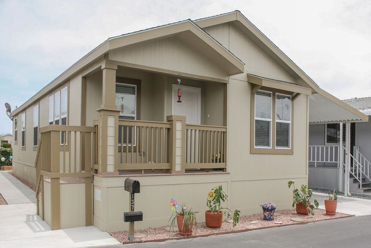 a mobile home is shown with potted plants in front