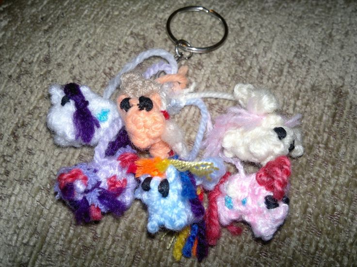 several crocheted keychains with different colors and designs are on the carpet