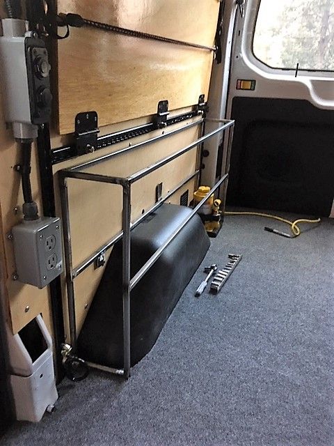 the inside of a van with its door open and tools on the floor next to it