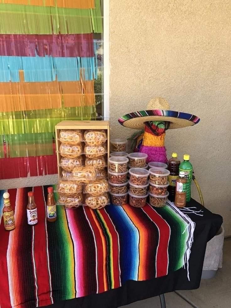 a table topped with lots of food and condiments next to a colorful wall