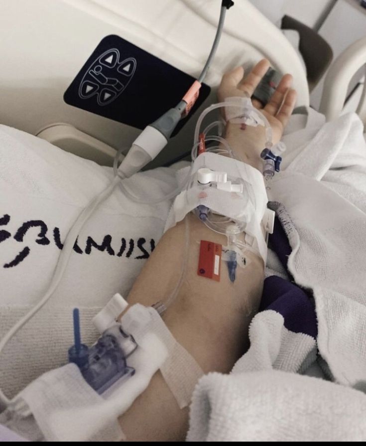 a person laying in a hospital bed with an iv