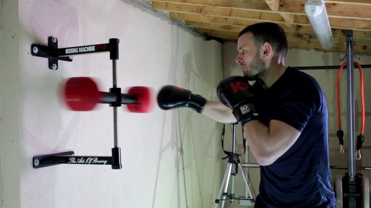 a man wearing boxing gloves hitting a punching bag