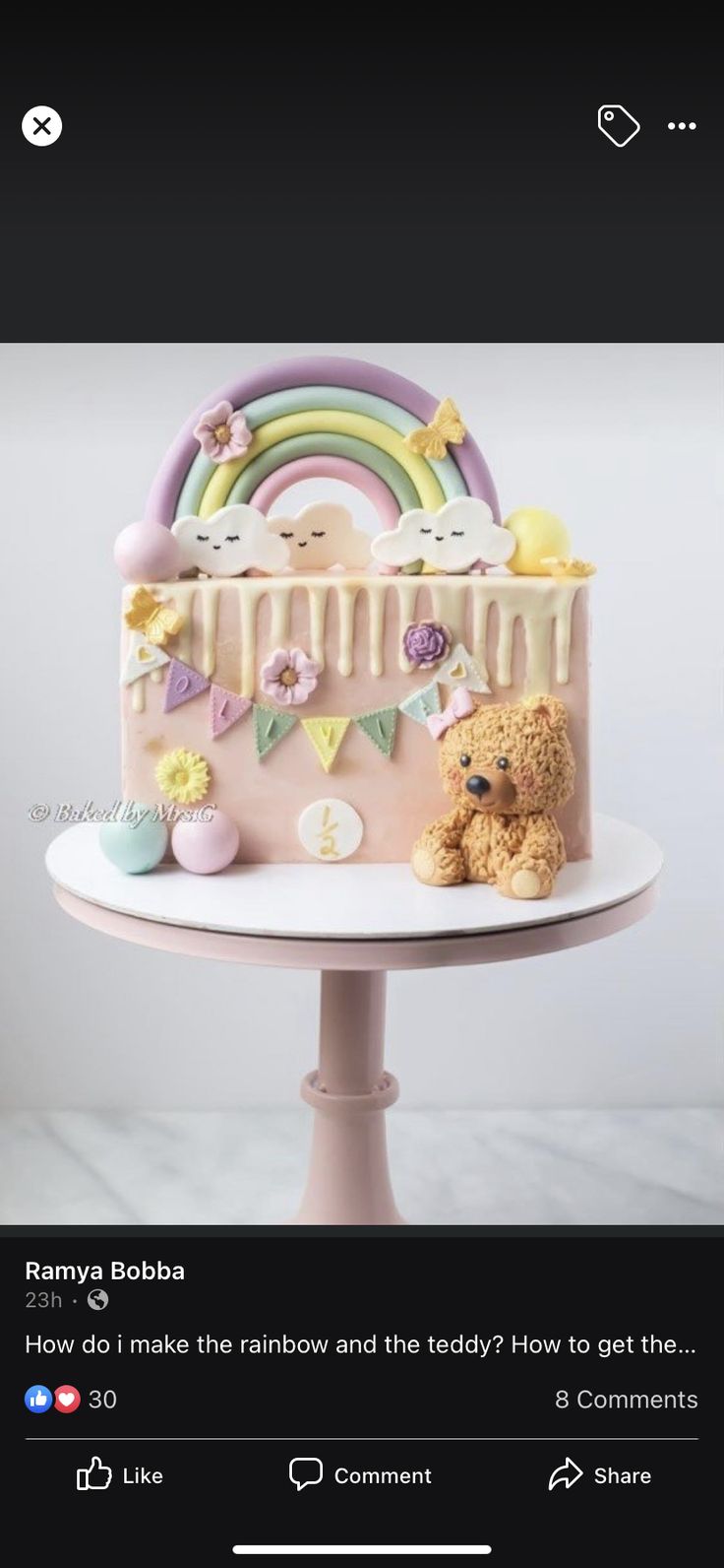 a pink cake sitting on top of a white table next to a brown teddy bear